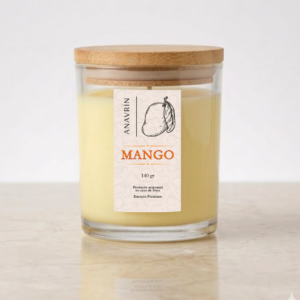 Vela artesanal de cera de soya con aroma a mango en frasco de cristal y tapa de bambú sobre una superficie beige lisa
