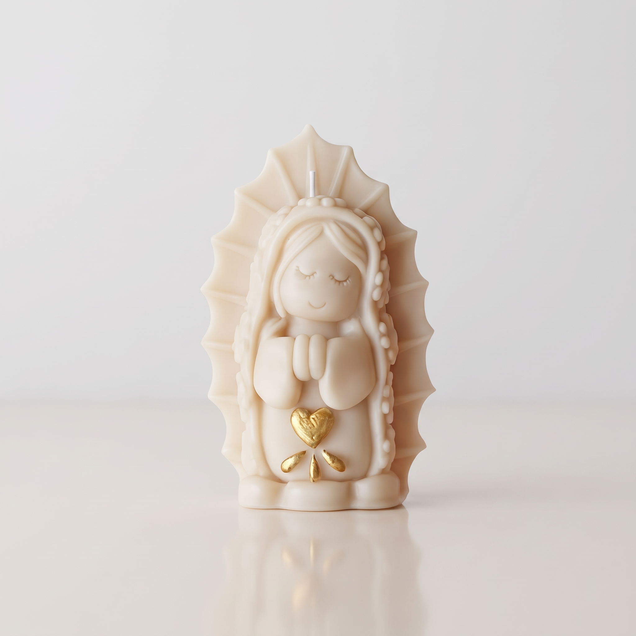 Vela Virgen María Decorativa - ANAVRIN Vela artesanal con forma de Virgen María rezando, con detalles dorados en el corazón, sobre un fondo minimalista y elegante.
