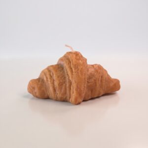 Vela decorativa artesanal hiperrealista en forma de croissant con textura de hojaldre dorado