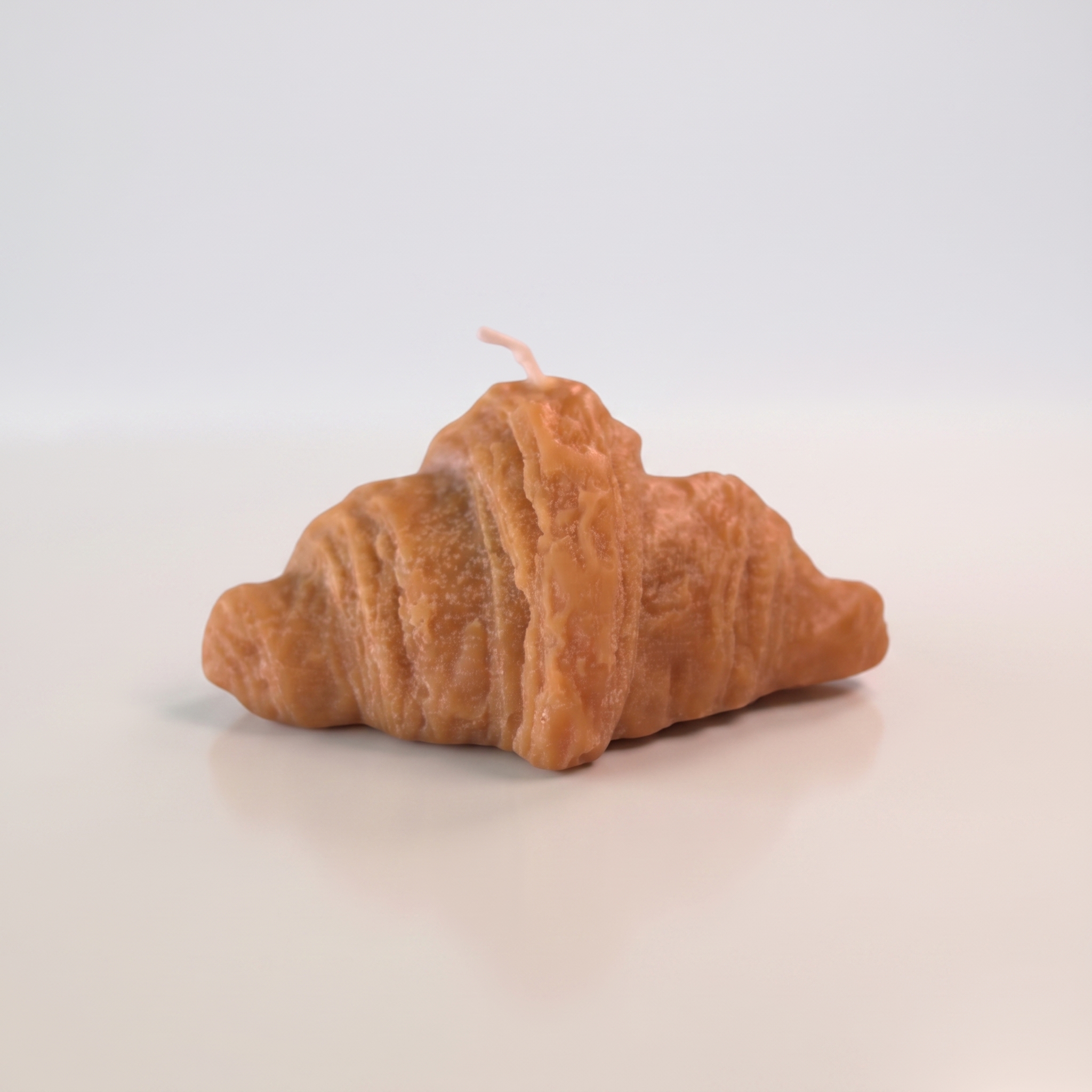 Vela Decorativa Croissant - ANAVRIN Vela decorativa artesanal hiperrealista en forma de croissant con textura de hojaldre dorado