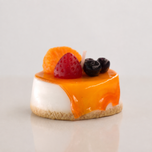 Vela decorativa artesanal hiperrealista en forma de postre panna cotta con sirope de naranja, fresa, mandarina y arándanos de cera