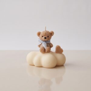 Conjunto de cinco velas artesanales con forma de ositos de peluche textura afelpada sobre nubes blancas con lazos celestes y corazones beige